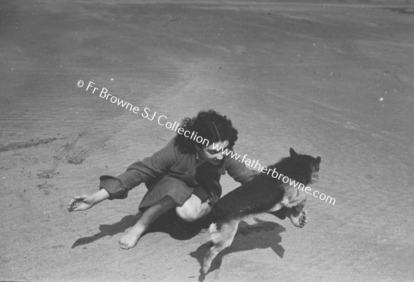 GIRL PLAYING WITH DOG ON BEACH